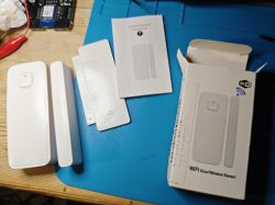 Tuya Door-Window Sensor with Accessories Tuya door-window magnetic sensor with packaging and manual on a table.