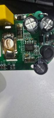 Close-up of a damaged circuit board with capacitors, resistors, and burned area.