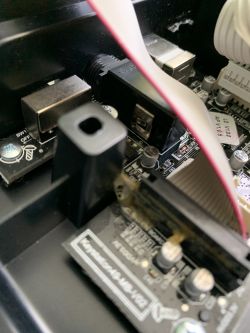 Zdjęcie wnętrza urządzenia elektronicznego z widocznymi portami USB i taśmą przewodzącą.
