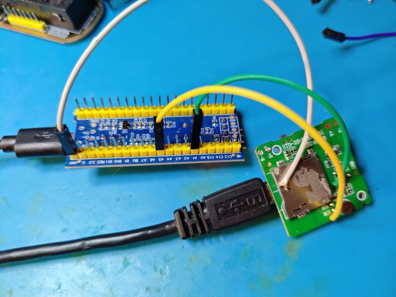 Programmer connection to SD card reader board Microcontroller programmer connected by wires to a PCB with an SD card reader.