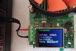 Battery capacity tester board showing “Complete!” and Wh, mAh, and time results, with wires attached