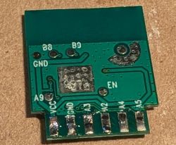 Close-up of an unpopulated green PCB with labeled pins and solder pads