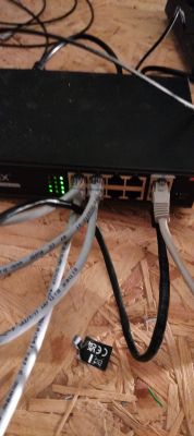 Zbliżenie na przełącznik PoE z kilkoma podłączonymi kablami Ethernet.