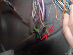 Dwie strzałki wskazują czerwony i zielony przewód w wiązce samochodowej.