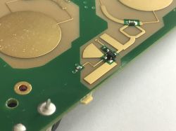 Close-up of a PCB with antenna-like copper areas and small SMD components