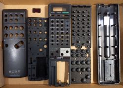 Części rozebranego pilota Sony RM-S470 w kartonowym pudełku.