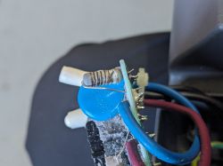 Widok bliski na płytkę elektroniczną z przewodami i komponentami, w tym rezystorem oznaczonym 2A, 350V.