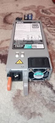 Zasilacz serwerowy Dell 750W leży na dywanie, widoczny wentylator i etykieta