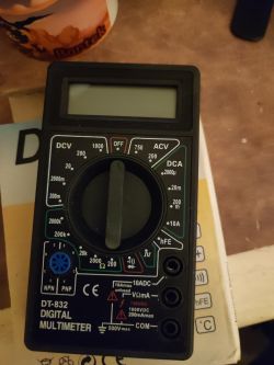 Cyfrowy multimetr DT-832 leży na stole.