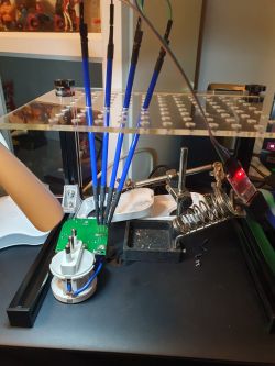 The image shows an electronics workstation with an Italian TUYA plug, a circuit board, and soldering wires.
