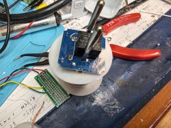 PCB with two relays and connected wires on an electronics workbench
