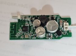 Circuit board with various electronic components, including capacitors and a coil.