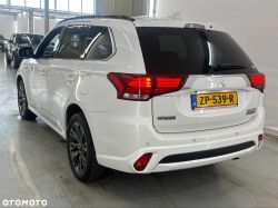 White Mitsubishi Outlander PHEV in a garage, rear view.