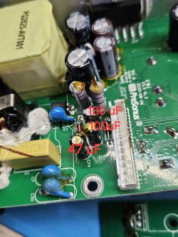 Zbliżenie na płytkę elektroniczną z kondensatorami oznaczonymi jako 100 uF i 47 uF.