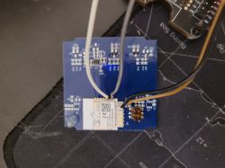 Blue circuit board with connected wires and a module.