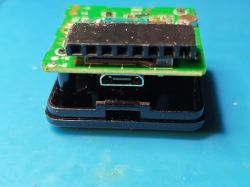 PCB with USB-C port and black pin header on blue surface