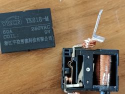 Disassembled YK818-M relay showing coil winding and internal contacts