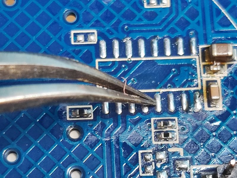 Close-up of Circuit Board with Pins Close-up of a blue circuit board with metal components aligned on pins.