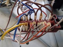 Zbliżenie na panel połączeń elektrycznych z kilkoma przewodami w różnych kolorach.