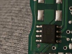Zbliżenie na układ scalony na zielonej płytce PCB z ośmioma pinami