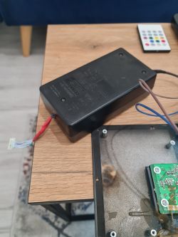 Black HP printer power supply on a table next to a scorched circuit board.