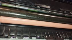 Wałki i folia fusera w drukarce HP Color LaserJet MFP M477fnw, z widocznymi śladami zużycia i dziwną teksturą na folii.