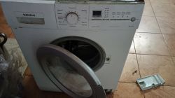 Pralka Siemens X10-36 z otwartymi drzwiczkami, ze zdjętą szufladą na detergenty.