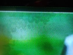 Zielony ekran plazmowego telewizora z dużą, nieregularną plamą u góry