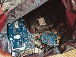 Computer electronic circuit boards in an anti-static bag, with a black vented module in a case.