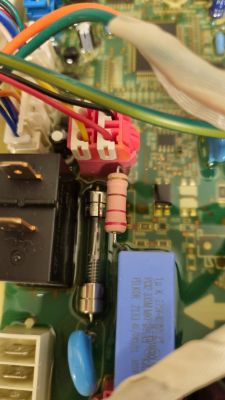 Zbliżenie na płytę elektroniki z uszkodzonym opornikiem w suszarce LG.
