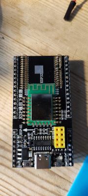 ESP Board with Wireless Module and Soldered Pins Photo of an ESP board with soldered pins and a wireless module.