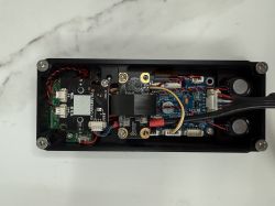 Interior of an Electronic Device View of the interior of an electronic device with visible components and wiring on a marble countertop.