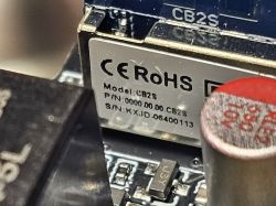 Close-up of CB2S electronic module with CE and RoHS labels on a metal surface
