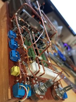 Zbliżenie na ręcznie zbudowany wzmacniacz z widocznymi komponentami elektronicznymi.