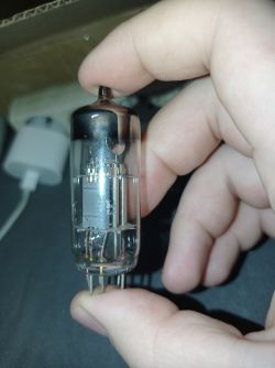 Rurka elektronowa trzymana w dłoni, widoczne szczegóły wewnętrzne i styki