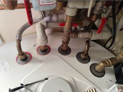 Widok na instalację wodną z plastikowymi rurami i zaworami.