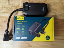 Treatlife Smart Plug-in Dimmer on Box Black Treatlife Smart Plug-in Dimmer device on a colorful cardboard box.