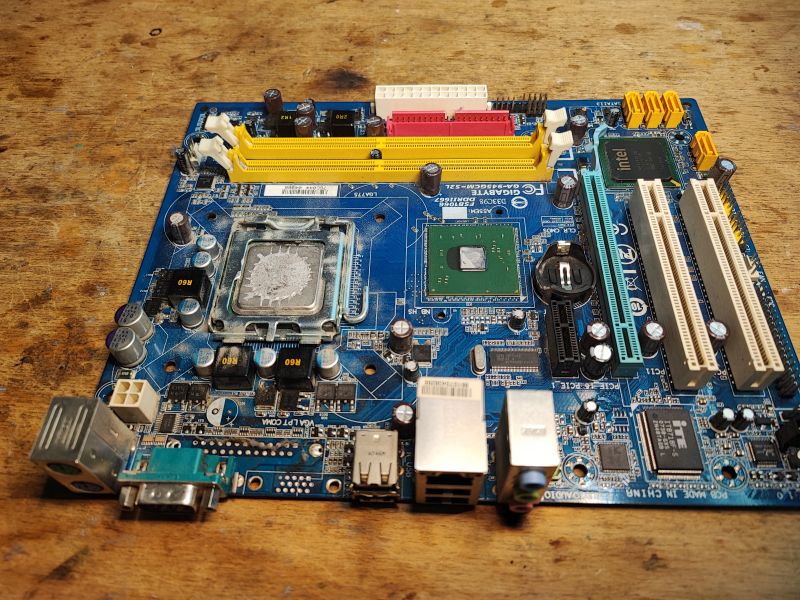 Computer Motherboard with Removed Components Old computer motherboard with visible components and slots.