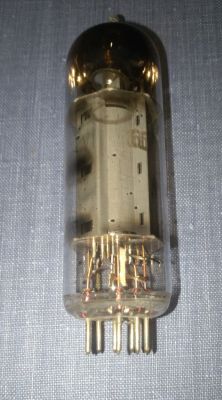 Lampa elektronowa z ośmioma pinami, widoczna na tle niebieskiego materiału.