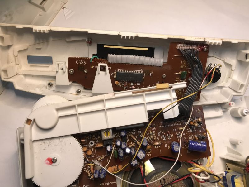 Interior of a kitchen radio with brown PCBs, tuning gear, wiring harness, and a round speaker