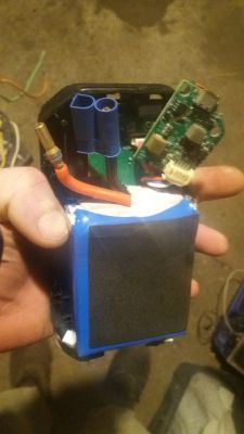 Bateria z widoczną elektroniką i połączeniami, trzymana w ręku.