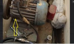Silnik elektryczny z żółtą strzałką wskazującą miejsce na obudowie