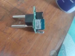 Electronic module of a smart plug from AliExpress on a wooden background.