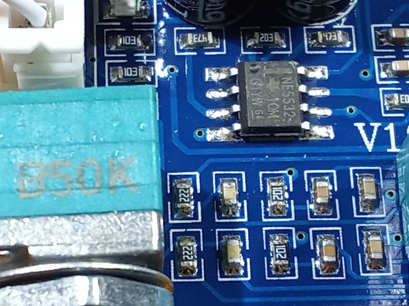 Zbliżenie na płytkę drukowaną z elementami elektronicznymi, w tym układ scalony NE5532 i różne rezystory.