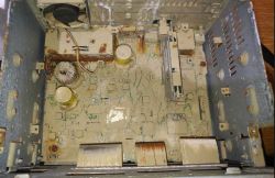 Interior of a rusted audio device with visible signs of corrosion.