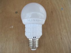 ZML2-7W RGB+CW LED bulb lying on a wooden surface.