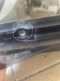 Zdjęcie blachy z dziurką na stole, zaznaczone kółkiem.