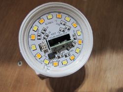 Interior of LED light bulb with visible circuit components Close-up of an LED bulb's internal circuit board with LEDs and components.