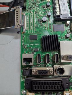Close-up of a green VESTEL mainboard with heatsink and HDMI, VGA, Ethernet, and SCART ports