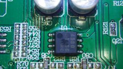 Nahaufnahme einer Leiterplatte mit einem integrierten Schaltkreis und zwei Elektrolytkondensatoren.